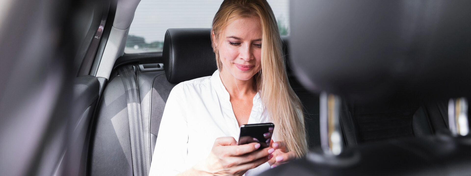 woman-with-phone-car-back-seat